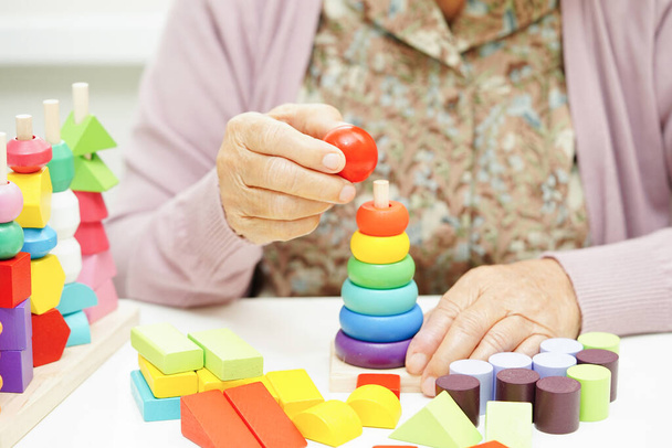 Asiatische ältere Frau beim Puzzlespiel zur Behandlung von Demenz und Alzheimer. - Foto, Bild