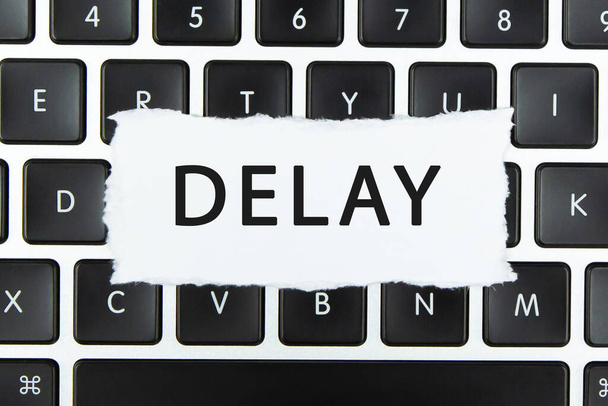 "Text Delay "auf zerrissenem Papier auf Laptop-Tastatur - Foto, Bild