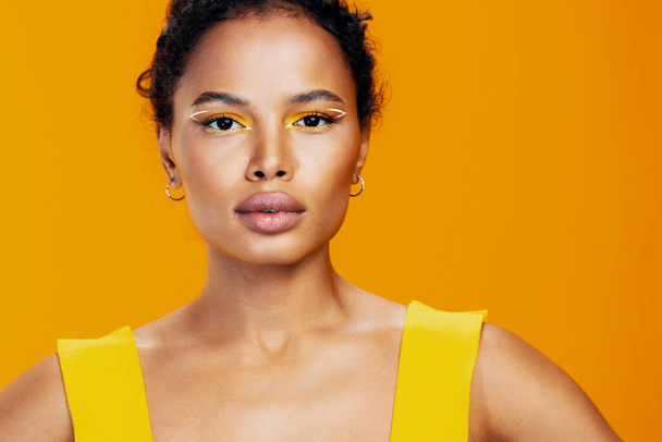 女性の笑顔スタジオファッションフェイスアフリカの化粧モデルメイクアップスタイルのポートレートカラフルな美しい肌黄色の創造的な美しさ黒の化粧品 - 写真・画像