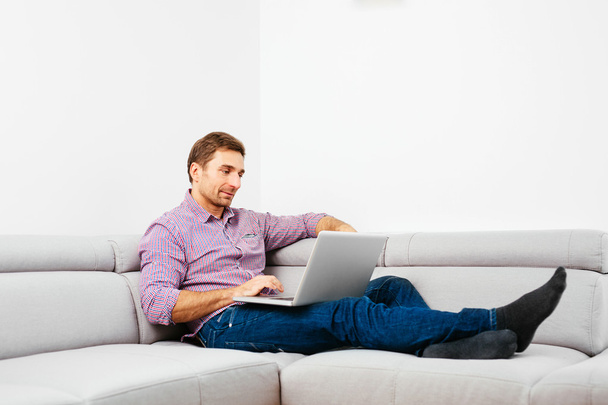 Человек на диване с ноутбуком
 - Фото, изображение