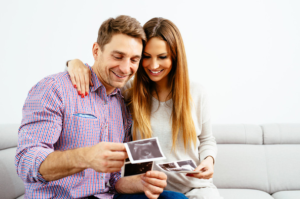 Pregnant couple looking at baby scans - Foto, imagen