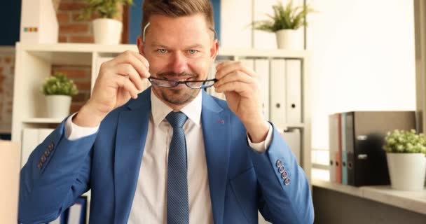 Smiling businessman putting on eyeglasses and crossing his arms 4k movie slow motion. Professional career growth of business concept - Footage, Video