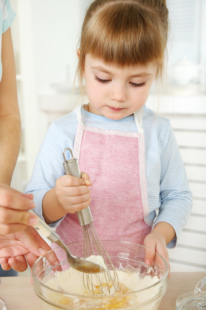 Little girl preparing cookies with  mother in kitchen at home - Zdjęcie, obraz