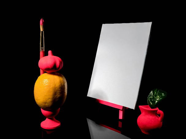 Bodegón creativo con limón y lienzo vacío sobre un fondo negro - Foto, imagen