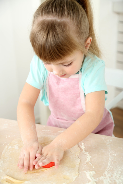 Little girl preparing cookies in kitchen at home - Foto, Imagen