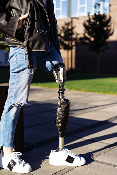 Detailní záběr mladé ženy, jak protéza zůstává ve městě. Žena s protetickou nohou. Žena s protézou nohou zařízení. - Fotografie, Obrázek