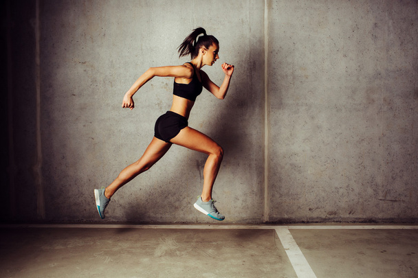 Slim attractive sportswoman running - Foto, afbeelding