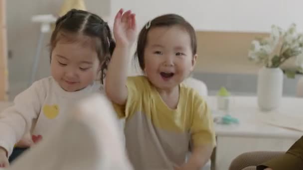 medio colpo di due divertente poco asiatico ragazza ridere mentre giocare con mamme insieme a accogliente casa - Filmati, video