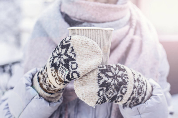 Giovane donna vestita calorosamente bere vino rimuginato caldo avendo lavorato guanti a maglia su mani - Foto, immagini