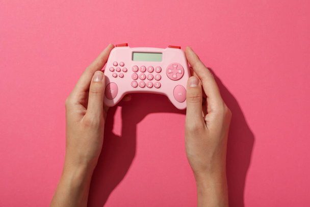 Calculator in hands on pink background, top view - Photo, Image
