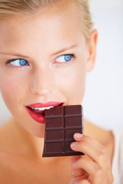 Eating woman face, thinking and looking at dark chocolate benefits, antioxidants wellness or junk food. Craving solution, taste and girl planning sugar product, cacao bar or sweets advertising plan. - Photo, Image