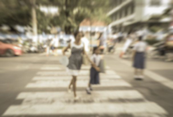 Blurred schoolchild with mother  walk crossing the street - Photo, Image