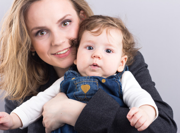 彼女の腕の中で小さな男の子と若い母親。母と息子の肖像画。金髪の美しい。胸筋の赤ちゃん。幸せな家族 - 写真・画像