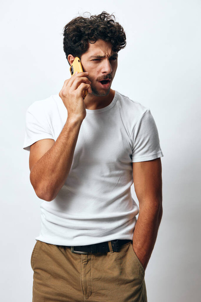 Henkilö mies tilalla aikuinen käyttäen joulua verkossa hipster t-paita viesti elämäntapa näköinen valkoihoinen puhelin teknologia latino muotokuva valkoinen komea matkapuhelin tausta chattailuun - Valokuva, kuva