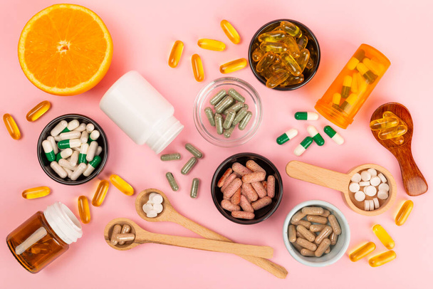 Vitaminen en supplementen. Verscheidenheid van vitamine tabletten in een pot op een textuur achtergrond.Multivitaminen met vers en gezond fruit.Voedingssupplementen. Plat gelegd. Ruimte voor tekst.Kopieer ruimte - Foto, afbeelding