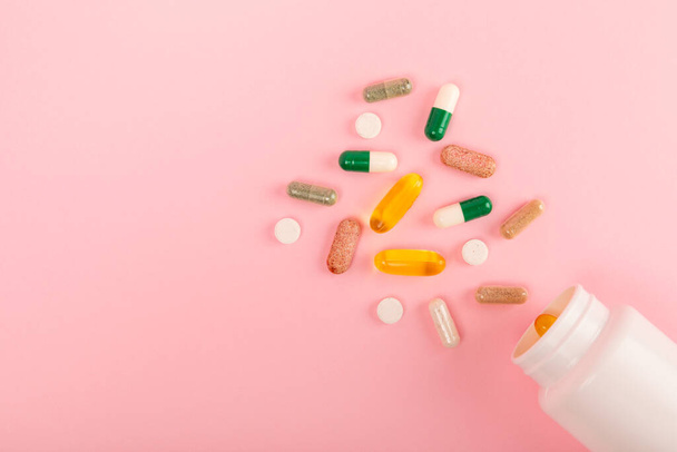 Vitamins and supplements. Variety of vitamin tablets in a jar on a texture background.Multivitamins with fresh and healthy fruits.Food supplements. Flat lay. Space for text.Copy space - 写真・画像