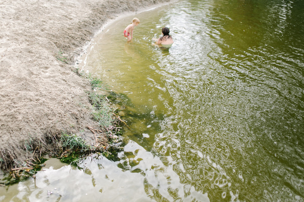 Mère et enfant jouant dans l'eau à la plage
 - Photo, image