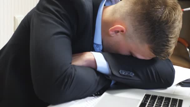 Nahaufnahme eines erschöpften Chefs im formellen Anzug, der auf dem Tisch im Büro einschläft. Jungunternehmer schläft auf Schreibtisch mit Laptop im Sitzungssaal. Müdes Manager-Nickerchen am Arbeitsplatz Zeitlupe. - Filmmaterial, Video