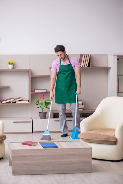 Giovane imprenditore pulizia della casa - Foto, immagini