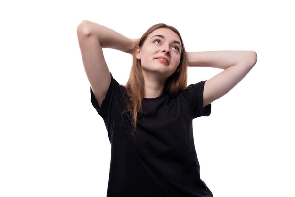 Una linda adolescente de pelo rubio con una camiseta negra está pensando:. - Foto, imagen