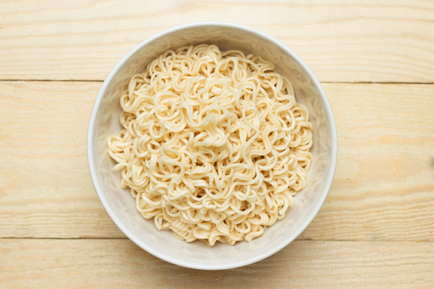 Instant noodles in white dish on wood background - Φωτογραφία, εικόνα