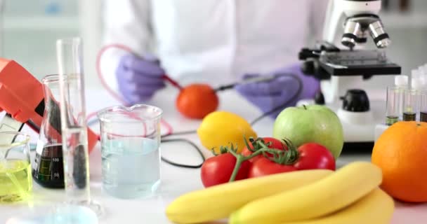 Laboratorní vědec pro kontrolu kvality potravin testuje zeleninu a ovoce. Vědec zkoumá vzorky ovoce a zeleniny na toxiny a GMO - Záběry, video