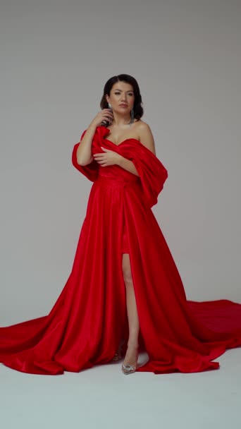 Brunetka w luksusowej długiej czerwonej sukience i wykwintnej biżuterii - Materiał filmowy, wideo