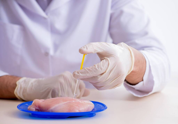 De mannelijke voedingsdeskundige die voedingsproducten test in het lab - Foto, afbeelding