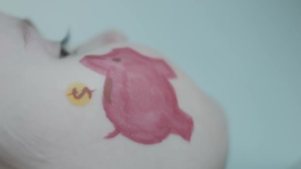 Piggy banco pintura no rosto de uma menina bonito criança. Conceito de banco, educação financeira e depósito - Filmagem, Vídeo