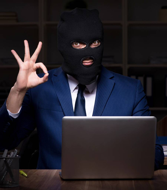 El empleado masculino robando información en la oficina por la noche
 - Foto, Imagen