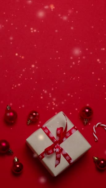 4k Achtergrond met Kerstmis verjaardag Nieuwjaar Geschenkdoos met rode strik en sprankelingen. Vallende gouden confetti met magisch licht op een prachtige donkerrode achtergrond. Ceremonie, evenement, vakantie stralend donker - Video