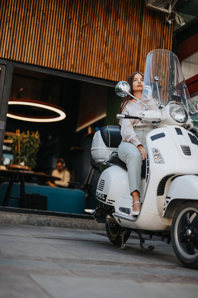 Confident businesswoman on a motorbike, discussing work and negotiating with a client. Market research and profit planning for sustainable online business project. Symbolizes opportunity and success. - Photo, Image