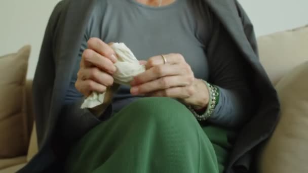 Recortado tiro de manos de mujer nerviosa jugueteando y desgarrando servilleta de papel mientras se sienta en el sofá durante la sesión de terapia - Metraje, vídeo