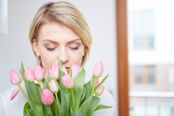 Beautiful blonde girl with tulips - Foto, Imagen