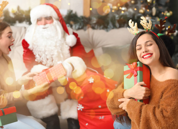 Giovane donna felice con regalo di Natale da Babbo Natale alla festa - Foto, immagini