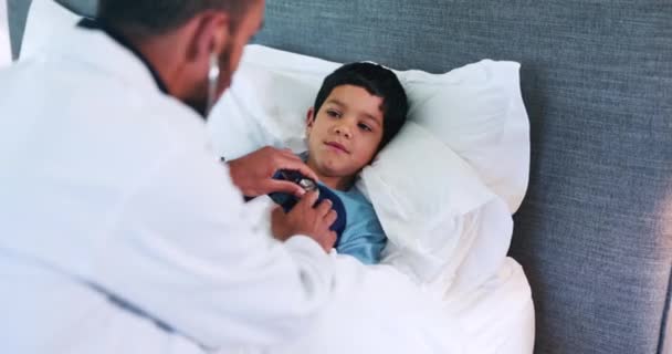 Lääkäri, poikalapsi ja stetoskooppi sängyssä yhteistyössä terveydenhuollon, arvioinnin ja tarkista hengitys. Lääke, lastenlääkäri ja lapsen kanssa keuhkoihin, kardiologiaan ja kysymyksiin kotona makuuhuoneessa. - Materiaali, video