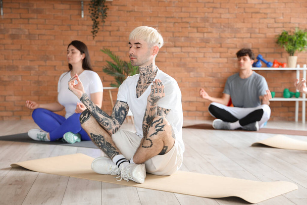 Группа спортивных людей, медитирующих в спортзале - Фото, изображение
