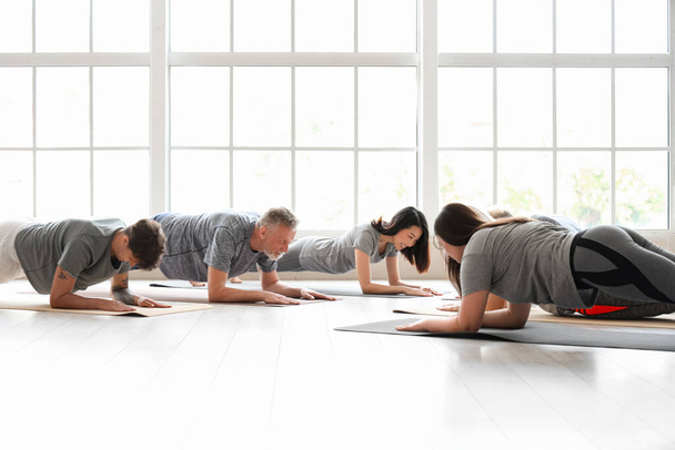 Group of sporty people doing plank in gym - Photo, Image