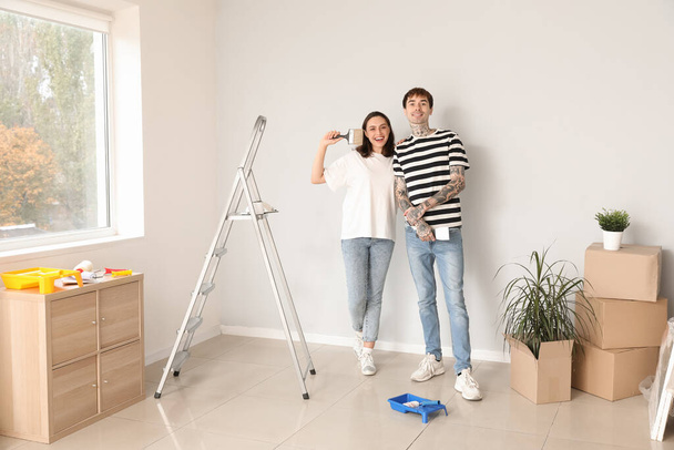 Giovane coppia con pennello e spatola facendo riparazione nella loro nuova casa - Foto, immagini