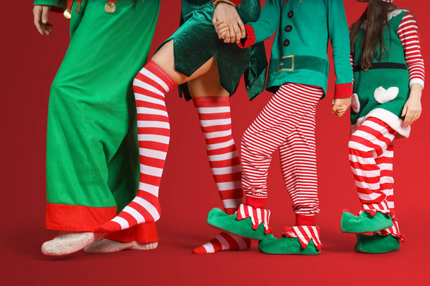 Famiglia felice in costume da elfo su sfondo rosso, primo piano - Foto, immagini
