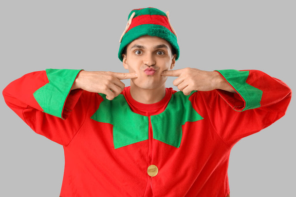 Handsome young man in elf's costume on grey background - Photo, Image