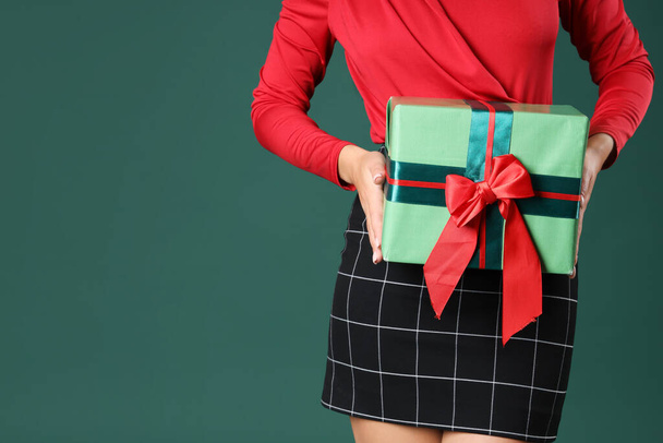 Belle jeune femme asiatique avec boîte cadeau sur fond vert, gros plan - Photo, image