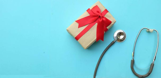медичний стетоскоп з подарунковою коробкою ізольовано на синьому пастельному тлі. концепція Різдво і Новий рік.горизонтальна фотографія - Фото, зображення