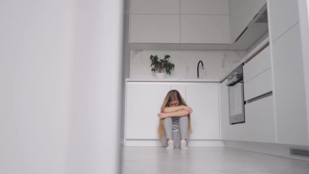 Een depressieve vrouw die op de grond zit en haar hoofd vasthoudt. Problemen in het gezin. - Video
