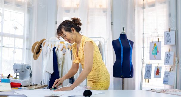 Dressmakers dokonuje dostosowania na muślina do nowych szytych na miarę sukni podczas pracy w pracowni warsztatowej artystycznej dla branży mody i odzieży - Zdjęcie, obraz