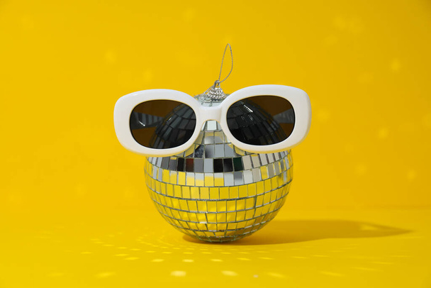Bolas de discoteca con gafas sobre fondo amarillo - Foto, Imagen