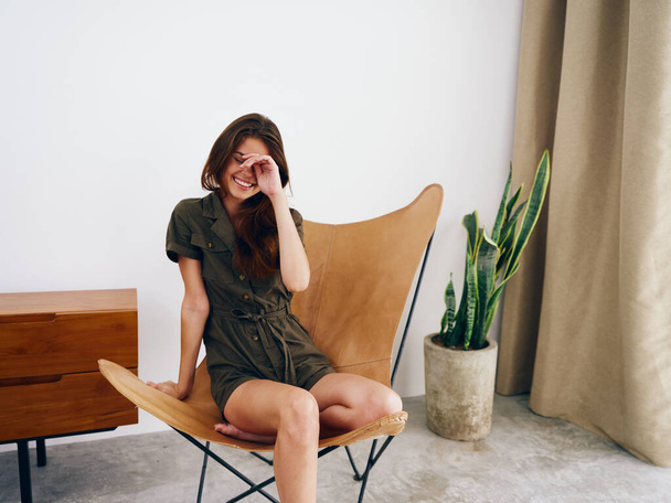 Женщина модель сидит на стуле на домашней улыбке, веселье и релаксация, современный стильный интерьер scandia образа жизни, копировать пространство. Высокое качество фото - Фото, изображение