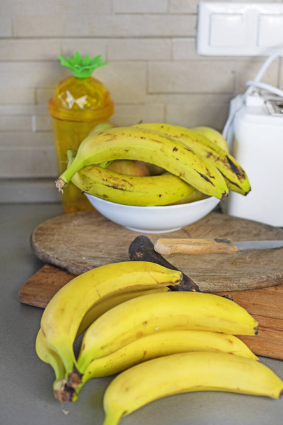 mazzo di banane gialle mature sul piano di lavoro in cucina - Foto, immagini