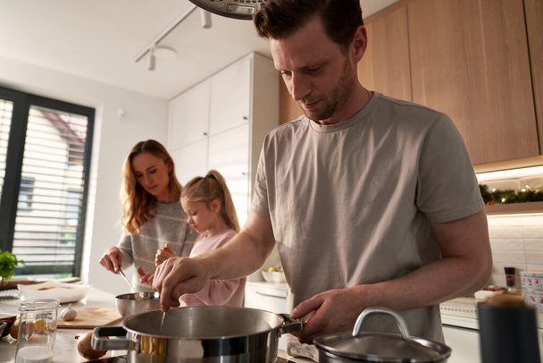 Valkoihoinen perhe kolme valmistelee ruokaa jouluksi kotitalouskeittiössä - Valokuva, kuva