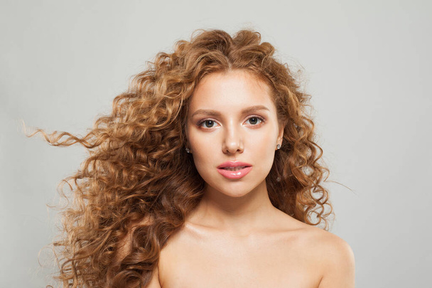Nice młoda modelka z naturalnym makijażem, jasną skórą i kręconą fryzurą na białym tle - Zdjęcie, obraz